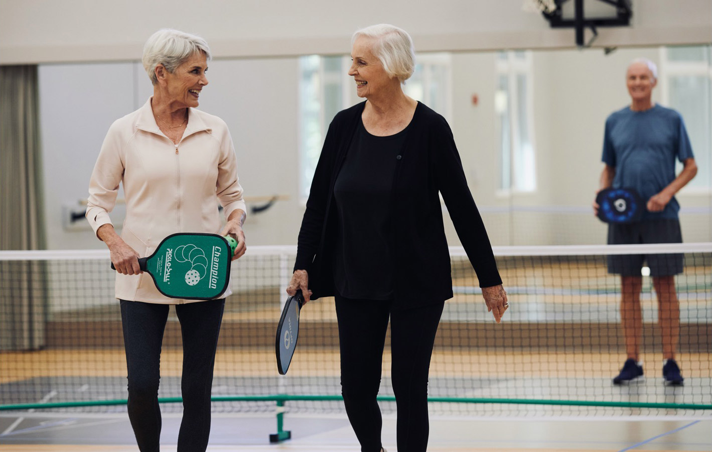 two ladies on a pickleball court